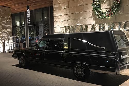 Black hearse parked in front of the JW Marriot Hotel for a tour