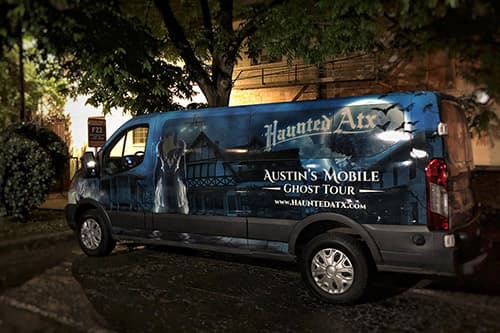 THe public van at night with the Haunted ATX logo and dead girl on the van
